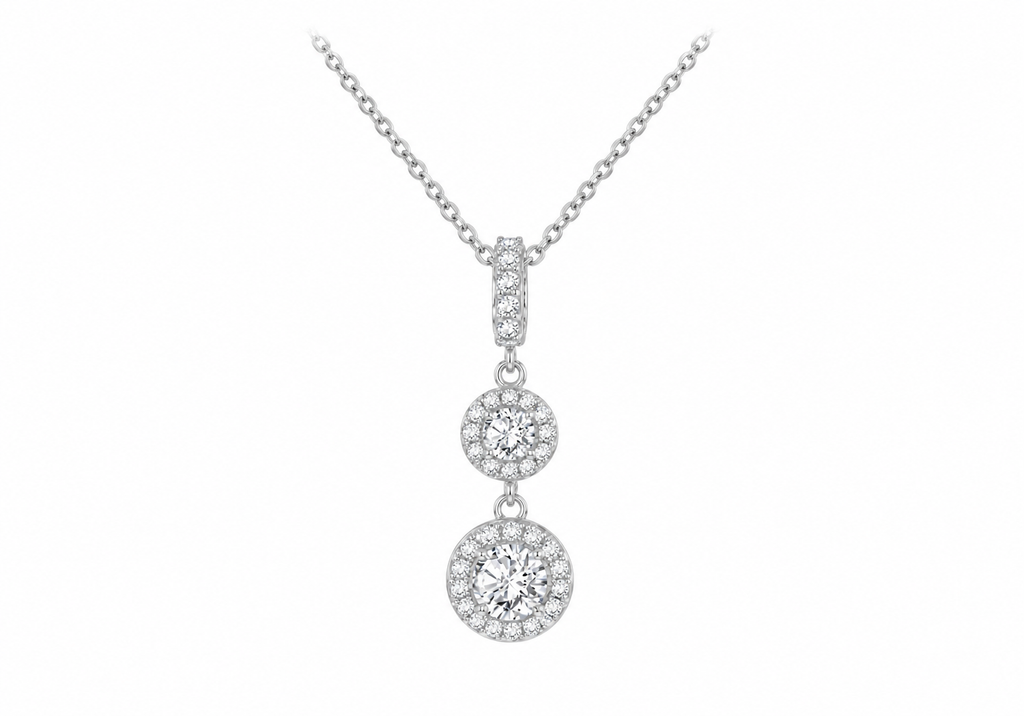 A silver-toned necklace with a multi-stone dangle pendant featuring three graduated round diamond clusters, shown against a plain white background.