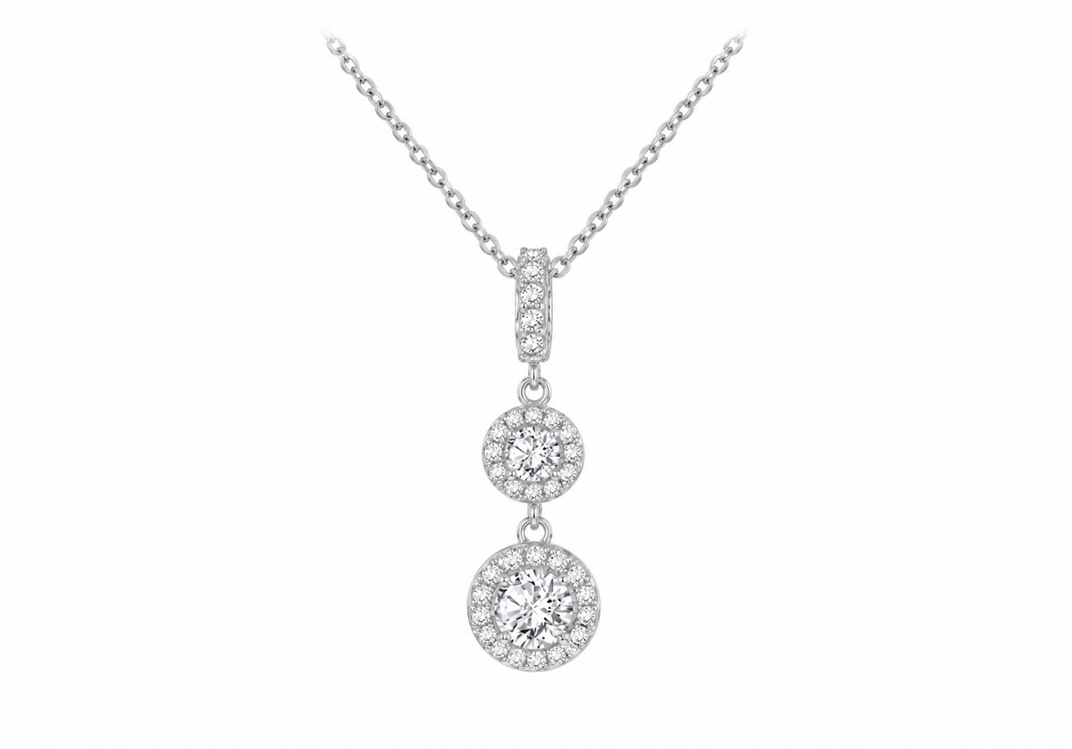 A silver-toned necklace with a multi-stone dangle pendant featuring three graduated round diamond clusters, shown against a plain white background.