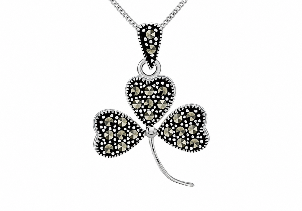A silver-toned shamrock pendant necklace embellished with small black and champagne-colored stones, shown on a white background.