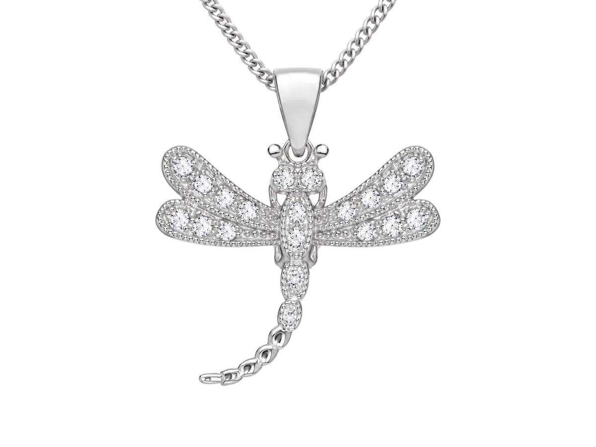 A silver dragonfly pendant necklace paved with small clear stones, hanging from a silver curb chain against a light gray background.